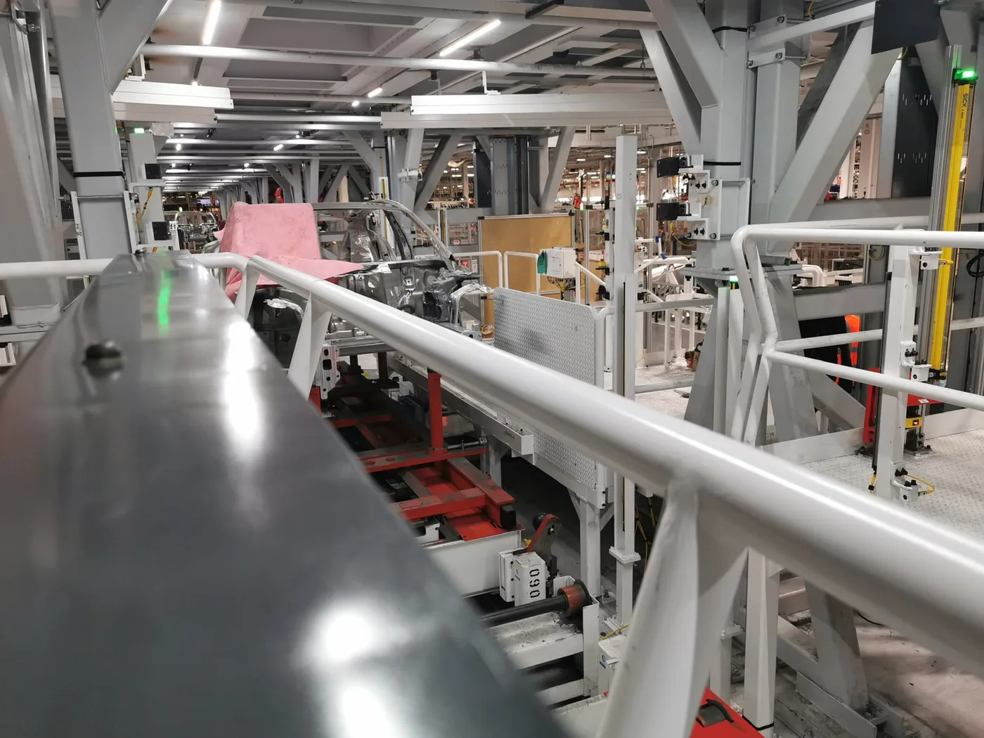 Línea de ensamble automotriz con estructura en proceso y paneles de control